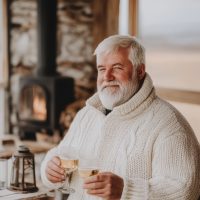 older-man-with-white-beard-sweater-holding-cup-coffee